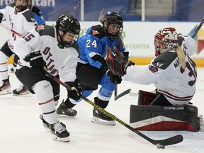 Ottawa goalie Emerance Maschmeyer and Toronto's Natalie Spooner look on as Ottawa's Savannah Harmon clears the puck during second- period PWHL action in Toronto on Sunday May 5, 2024.