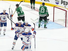 Edmonton Oilers centre Connor McDavid, bottom left, celebrates with teammates defenceman Evan Bouchard (2), and left wing Zach Hyman after scoring the game-winning goal during the second overtime in Game 1 of the NHL hockey Western Conference Stanley Cup playoff finals, Thursday, May 23, 2024, in Dallas.