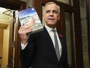 Prime Minister Mark Carney holds a copy of the 2025 budget.