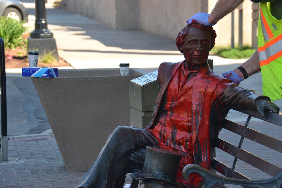 City workers clean off red paint dumped on the John A. Macdonald statue on June 19, 2020.