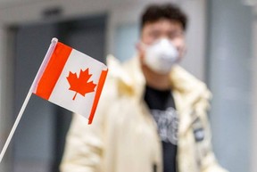 A traveller wears a mask at Pearson airport arrivals, shortly after Toronto Public Health received notification of Canada's first presumptive confirmed case of novel coronavirus, in Toronto on Jan. 26, 2020. REUTERS/Carlos Osorio