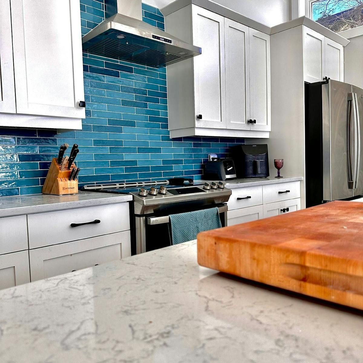 Damien Packwood of Charlottetown, P.E.I. creates an eye-catching bright blue kitchen backsplash that injects the much-needed colour into a neutral space. - Contributed