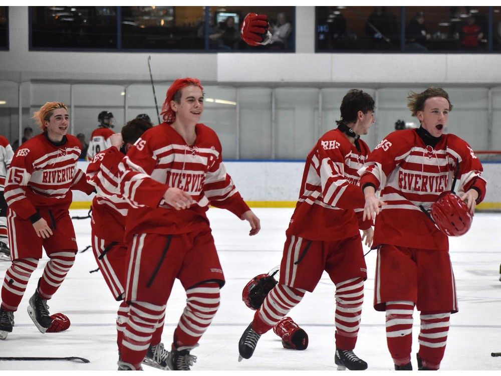 Members of the Riverview Ravens celebrate after winning the School Sport Nova Scotia Highland Region Division 1 hockey championship with a 7-4 victory over the Glace Bay Panthers at Miners Forum in Glace Bay on Thursday. From left, Ayden Ball, Carter MacDonald, Lucas Phillippo and Ty MacDonald. JEREMY FRASER/CAPE BRETON POST