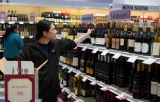 Chris Wong pulls bottles of American wine from the shelves at the NSLC's Bayers Lake location on Monday, Feb. 3, 2025.