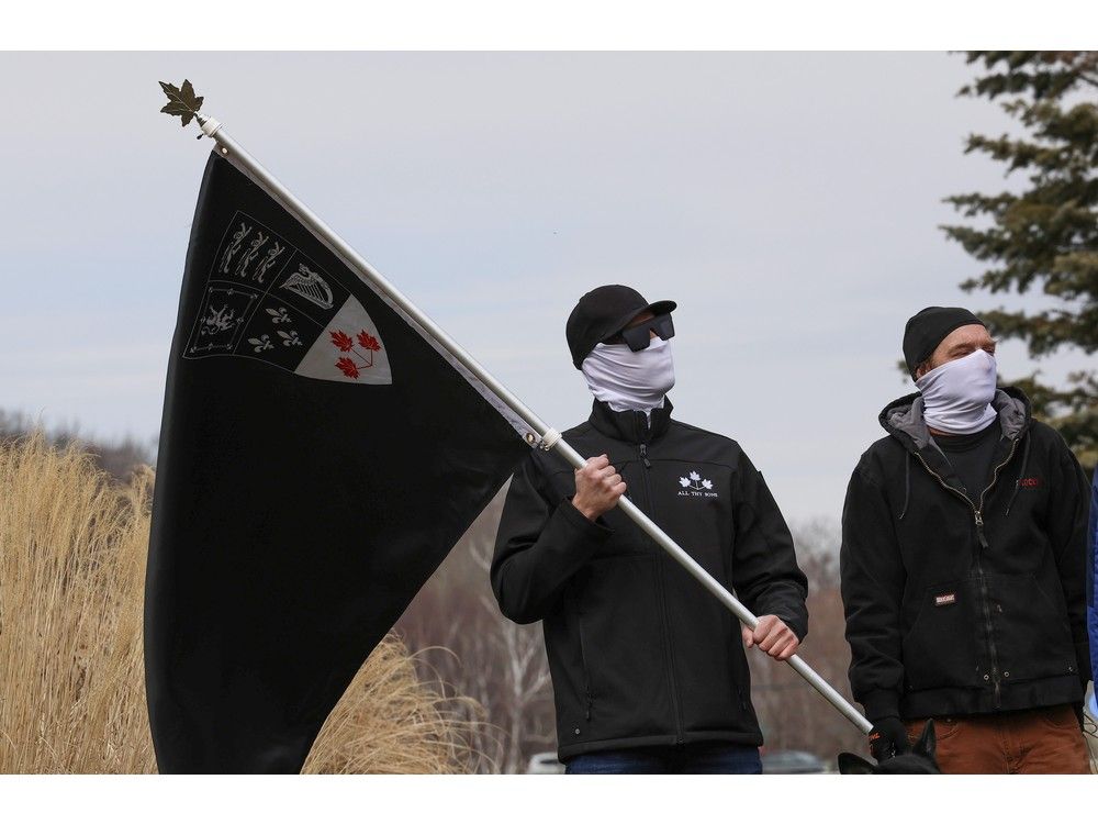 Masked members of an alt-right group Second Sons Canada posed in front of the Sullivan’s Pond cenotaph in Dartmouth on Sunday.