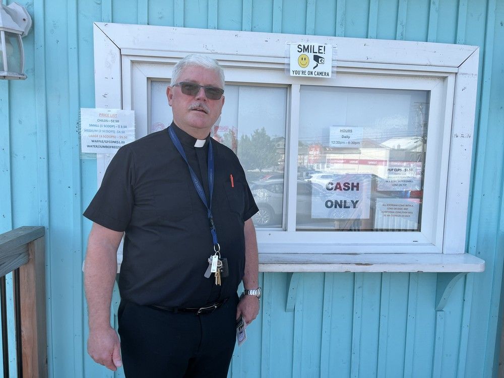  rev. gerald david stands in front of the heavenly scoops ice cream shop on the edge of the parking lot of st. bernard’s church in enfield after mass on sunday.