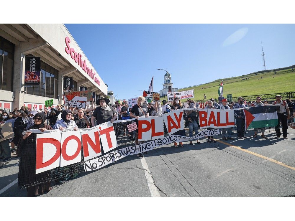 Several marchers hold an oversized tennis net with the message, ‘Don’t Play Ball’ on Brunswick Street. – TIM KROCHAK Several marchers hold an oversized tennis net with the message, ‘Don’t Play Ball’ on Brunswick Street. – TIM KROCHAK