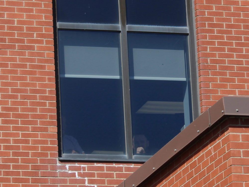A viewer inside the Cape Breton Regional Police Service headquarters witnesses Thursday’s rally against the federal buyback program for prohibited firearms. Police headquarters were closed to the public for the day. A viewer inside the Cape Breton Regional Police Service headquarters witnesses Thursday’s rally against the federal buyback program for prohibited firearms. Police headquarters were closed to the public for the day.