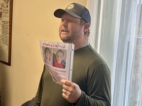 Nick Oldrieve, co-founder of Please Bring Me Home, an Ontario-based not-for-profit group, holds a poster of Lilly and Jack Sullivan while speaking to a group of volunteers inside Union Centre Community Hall in Pictou County prior to a search of the missing children on Saturday morning.