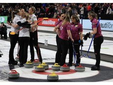Team Homan celebrate while Team Black commiserate following Homan's 5-4 win in the first game of the best-of-three final at the Canadian curling trials in Halifax on Friday, Nov. 28, 2025.
