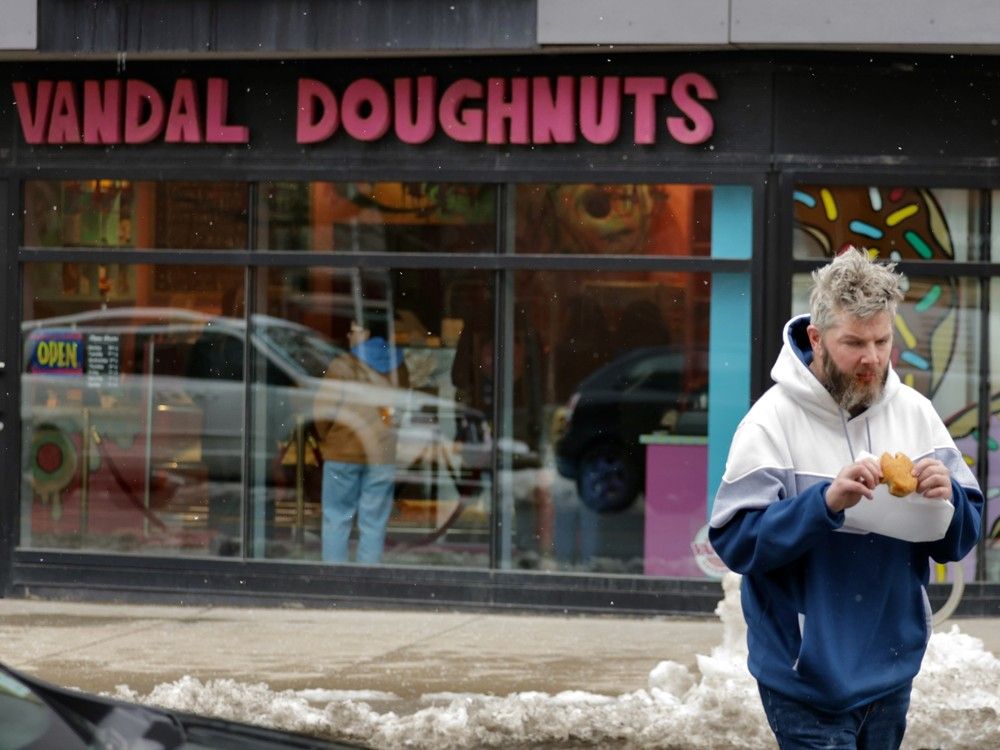 Aaron MacLeod prepares to eat a jam buster from Vandal Doughnuts on Gottingen St. in Halifax on Friday. MacLeod said he was a regular customer and that it was unfortunate the shop will be closing on Sunday.