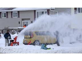 Lucas Ruiz-Gil puts Erik Johansen, right, under a snow blast while clearing the driveway of the Johansen household in Eastern Passage on Tuesday. Looking on is Elsa Johansen.