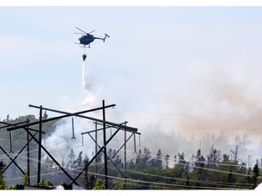 A water-bomber helicopter drops water onto a brush fire near Bayers Lake Industrial Park in Halifax in 2016. - FILE