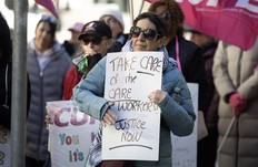 Long-term care workers and supporters rally outside Province House on Monday.
