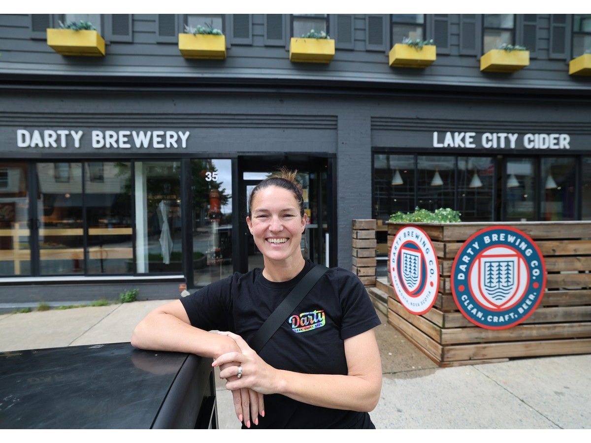 Poet Comeau, owner of Lake City Cider and Darty Brewery, stands in front of her Portland Street establishments in Dartmouth on Wednesday.