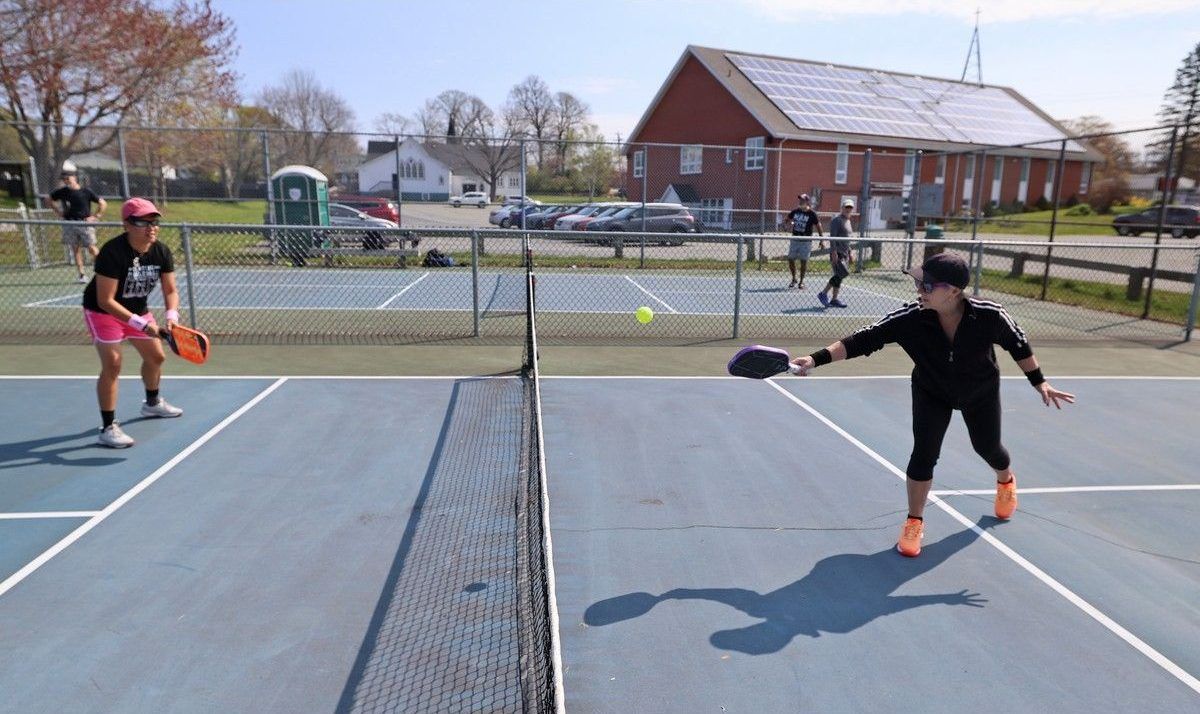 Pickleball players Tanya Maier, left, and Marina Hebert warm up while on deck to play a match at the Morash Park pickleball courts in Dartmouth on May 14, 2025.