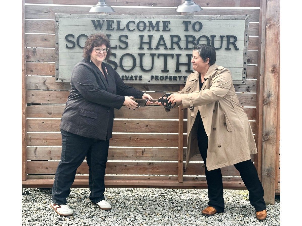 Yarmouth-born entrepreneur, philanthropist, and a champion of the trades, Mandy Rennehan, right, presents the symbolic key to Michelle Porter, CEO of Souls Harbour Rescue Mission, as Rennehan donated her Rennesouth short-term rental property to Souls Harbour, which will operate the property as a social enterprise. TINA COMEAU