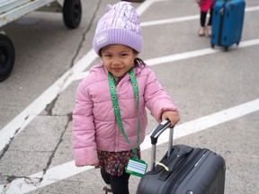 Two-year-old Elise Bugayong pushes her bag as she gets set to board an Air Canada flight as part of an Austism Aviators event in Charlottetown.