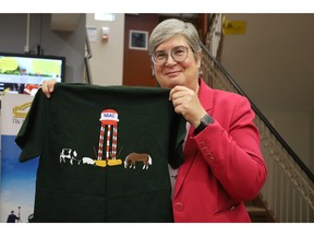 Heather Bruce, dean of the Faculty of Agriculture at Dalhousie University, holds a 2009 College Royal shirt with a graphic that includes the campus water tower. The historic water tower has been used in school merchandise over the years.