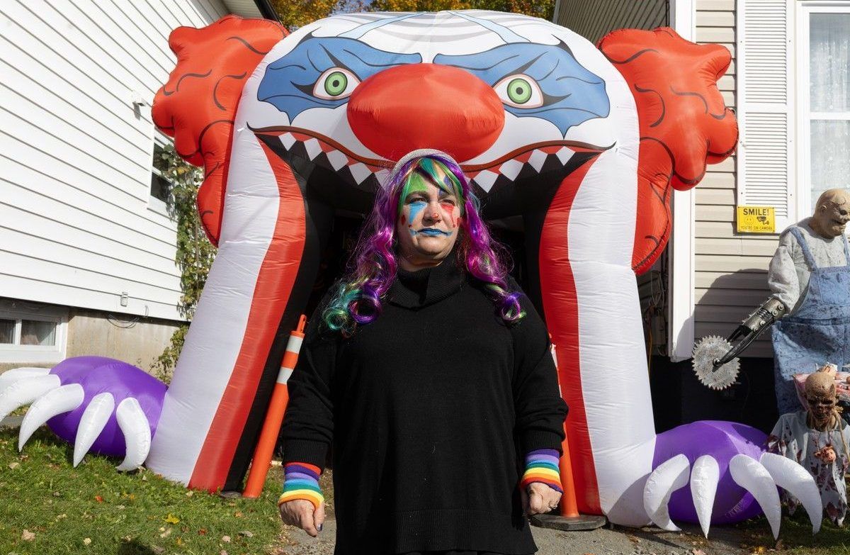 Christina MacDonald poses for a photo in front of her extensive Halloween decorations outside her Dartmouth home on Saturday.