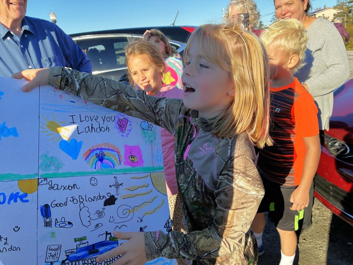 A young girl hands Landon Smith a poster made for him during a welcome home celebration from the community after completing a two-week, 804-kilometre run from one tip of Nova Scotia to the other in support of Autism Nova Scotia. KATHY JOHNSON