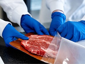 Employees at Freshr Technologies use the company's product to package a piece of beef. - SUPPLIED BY FRESHR TECHNOLOGIES