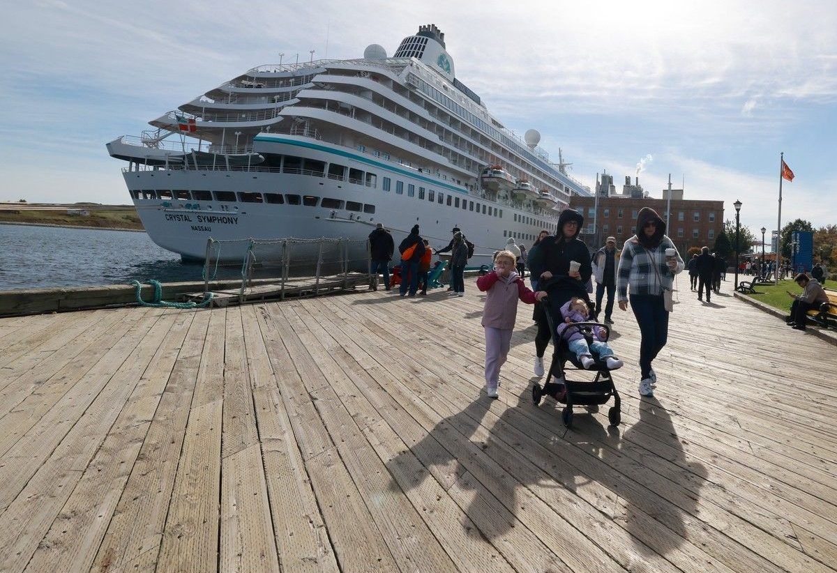 Passengers from the cruise ship, Oasis of the Seas, walk along the Halifax waterfront on Wednesday. At rear is the cruise ship, Crystal Symphony. The Oasis of the Seas was originally headed to the Bahamas but was rerouted to Halifax due to poor weather.