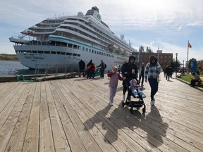 Passengers from the cruise ship, Oasis of the Seas, walk along the Halifax waterfront on Wednesday. At rear is the cruise ship, Crystal Symphony. The Oasis of the Seas was originally headed to the Bahamas but was rerouted to Halifax due to poor weather.