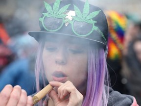 FILE: A woman smokes marijuana on Parliament Hill on 4/20 in Ottawa, Ontario, Apr. 20, 2017. /
