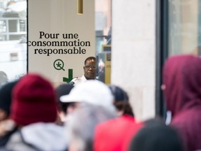 FILE - A sign reads "for a responsible usage" as people enter a cannabis store on October 17, 2018 in Montreal, Quebec.