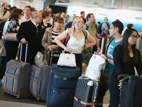 FILE: Passengers wait in line to reschedule flights at O'Hare International Airport on Sept.  26, 2014 in Chicago, Ill. /