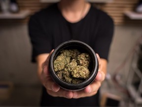 FILE: An employee displays marijuana for sale at the Village Bloomery dispensary in Vancouver, on Monday Sept. 17, 2018.
