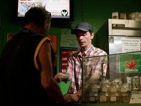 FILE: Baker and customer service employee, Shawn Saunders, sells product to a customer, at the Cannabis Buyers Club, in Victoria B.C., Thursday June 11, 2015. /