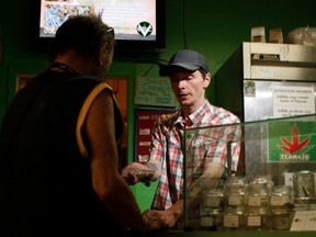 FILE: Baker and customer service employee, Shawn Saunders, sells product to a customer, at the Cannabis Buyers Club, in Victoria B.C., Thursday June 11, 2015.