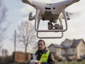 FILE: Marek Witkowski, policeman, powers-up a four rotor drone to detect illegal burning of coal and trash for household heating at residential property in Krakow, Poland, on Thursday, Dec. 12, 2019.