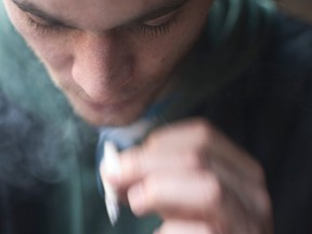 young male smoking or vaping cigarettes or cannabis