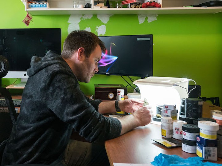  Cannabis reviewer Brad Martin inspects a nug in his home office.