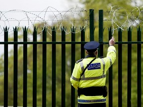 FILE: An Irish police officer checks razor wire ahead of the EU enlargement ceremony Apr. 30, 2004 in Dublin, Ireland. /