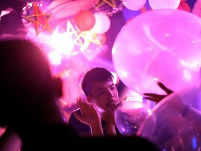 FILE: In this picture taken on Sept. 22, 2018, a Vietnamese youth inhales a "funky balloons" filled with laughing gas, at a nightclub in Hanoi.