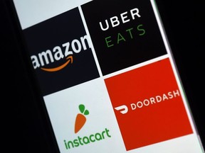 FILE: This illustration picture shows delivery applications logos from Amazon, Uber Eats, Instacart and Doordash displayed on a smartphone on Apr. 10, 2020, in Arlington, Vir. /