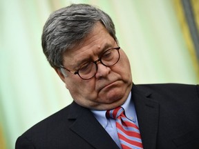 FILE: U.S. Attorney General Bill Barr waits before US President Donald Trump signs an executive order about social media in the Oval Office of the White House in Washington, DC on May, 28, 2020.