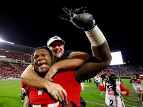 Head coach Kirby Smart of the Georgia Bulldogs leaps on the back of Isaiah Wilson #79 as they celebrate their 19-13 win over the Texas A&M Aggies at Sanford Stadium on November 23, 2019 in Athens, Georgia.