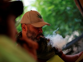 Activist Jose Rivera, part of the Cannabico Mexican Movement, smokes while working inside the protest cannabis garden next to Mexico's Senate building during a call for legalization in Mexico City, Mexico Sept. 24, 2020.