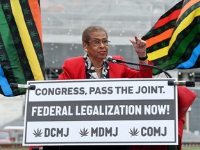 FILE: Activists from the DC Marijuana Justice (DCJM) wave flags during a rally to demand Congress to pass cannabis reform legislation on the East Lawn of the US Capitol in Washington, DC on Oct. 8, 2019