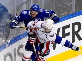 Anthony Cirelli #71 of the Tampa Bay Lightning and Jonas Siegenthaler #34 of the Washington Capitals collide along the boards during the third period in Game One of the Eastern Conference Qualification Round prior to the 2020 NHL Stanley Cup Playoffs at Scotiabank Arena on August 03, 2020 in Toronto, Ontario.