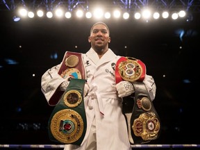 Anthony Joshua poses with his belts after his WBA, IBF, WBO & IBO Heavyweight Championship title fight at Joseph Parker Principality Stadium on March 31, 2018 in Cardiff, Wales.