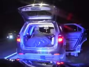 Image of SUV containing a trash bag filled with smaller bags of cannabis.