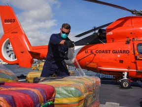 Coast Guard Petty Officer 3rd Class Garret Byrd wraps bails at Port Everglades, Florida, Dec. 16, 2020. /