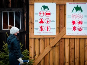 Covid-19 safety measures are posted while shoppers search for a Christmas tree at a farm in Harrowsmith, Ontario, Canada, on Dec. 5, 2020. /