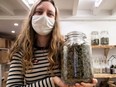 Shop teller Julie T'ioen poses with a jar of hemp flower in Paris on February 2, 2021.